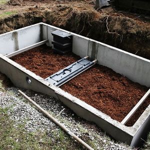 A large concrete box filled with dirt and wood chips