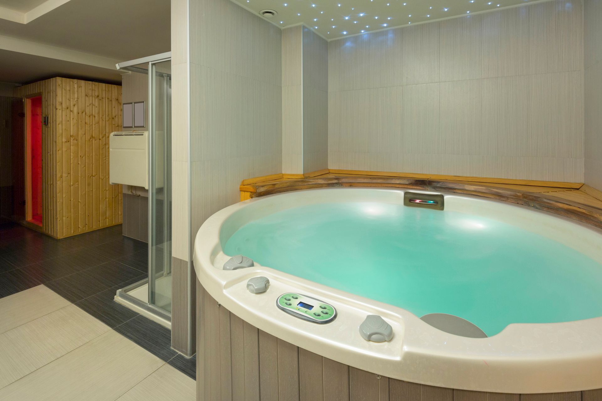 Hot tub, shower, and sauna in a sleek modern spa room.