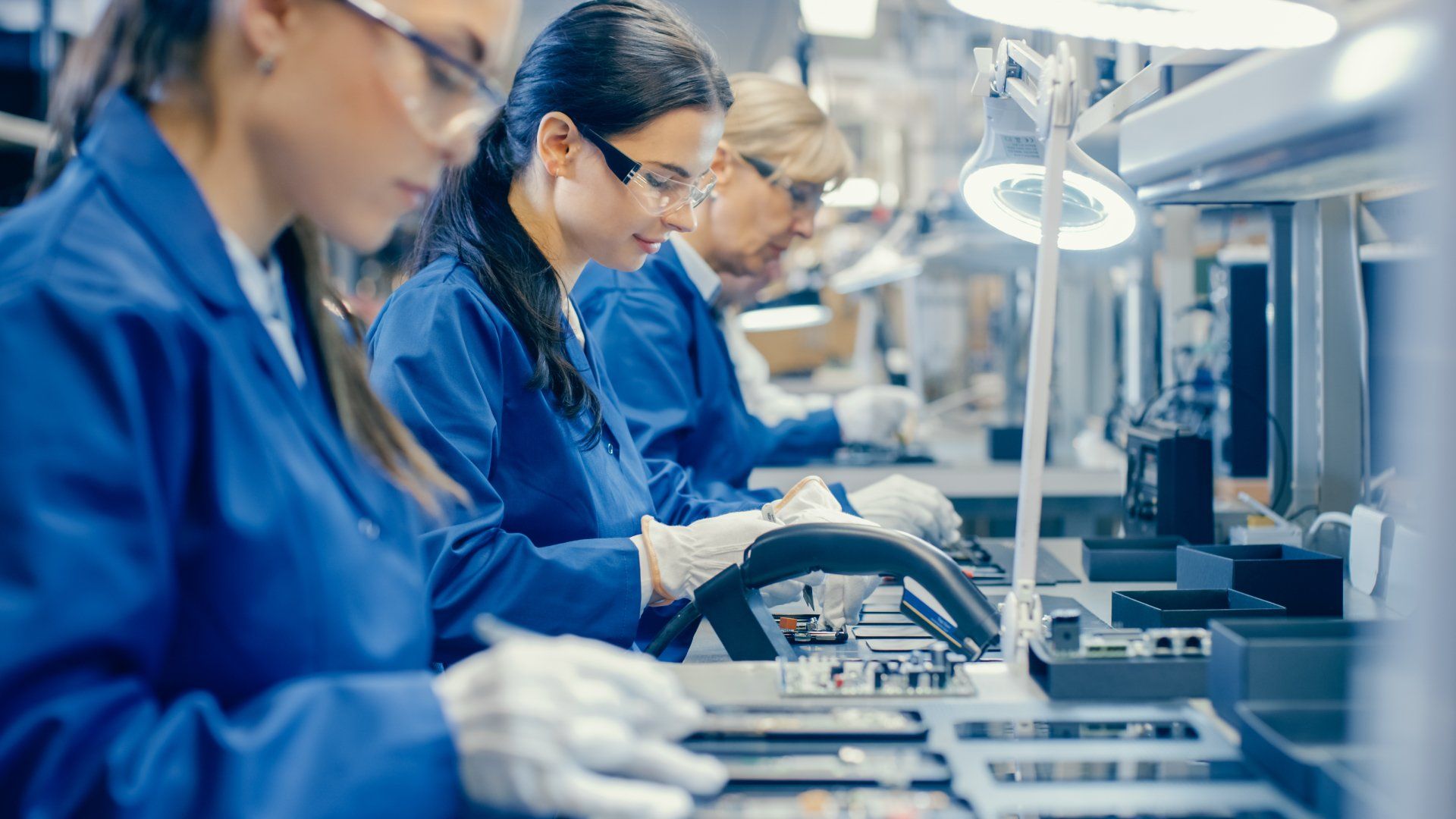 A group of women are working on a conveyor belt in a factory.