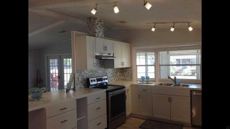 A kitchen with white cabinets and stainless steel appliances