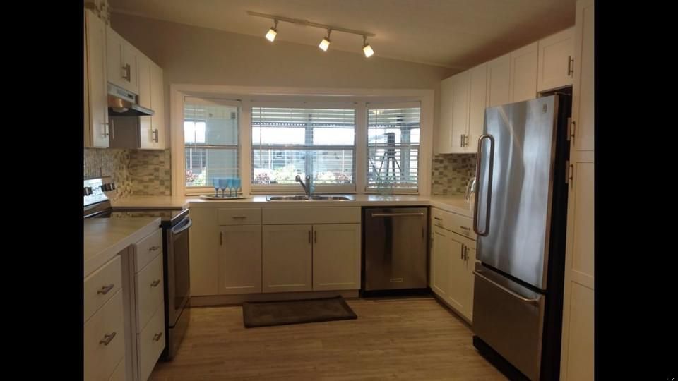 A kitchen with white cabinets and stainless steel appliances