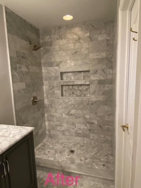 A bathroom with a walk in shower and a sink.