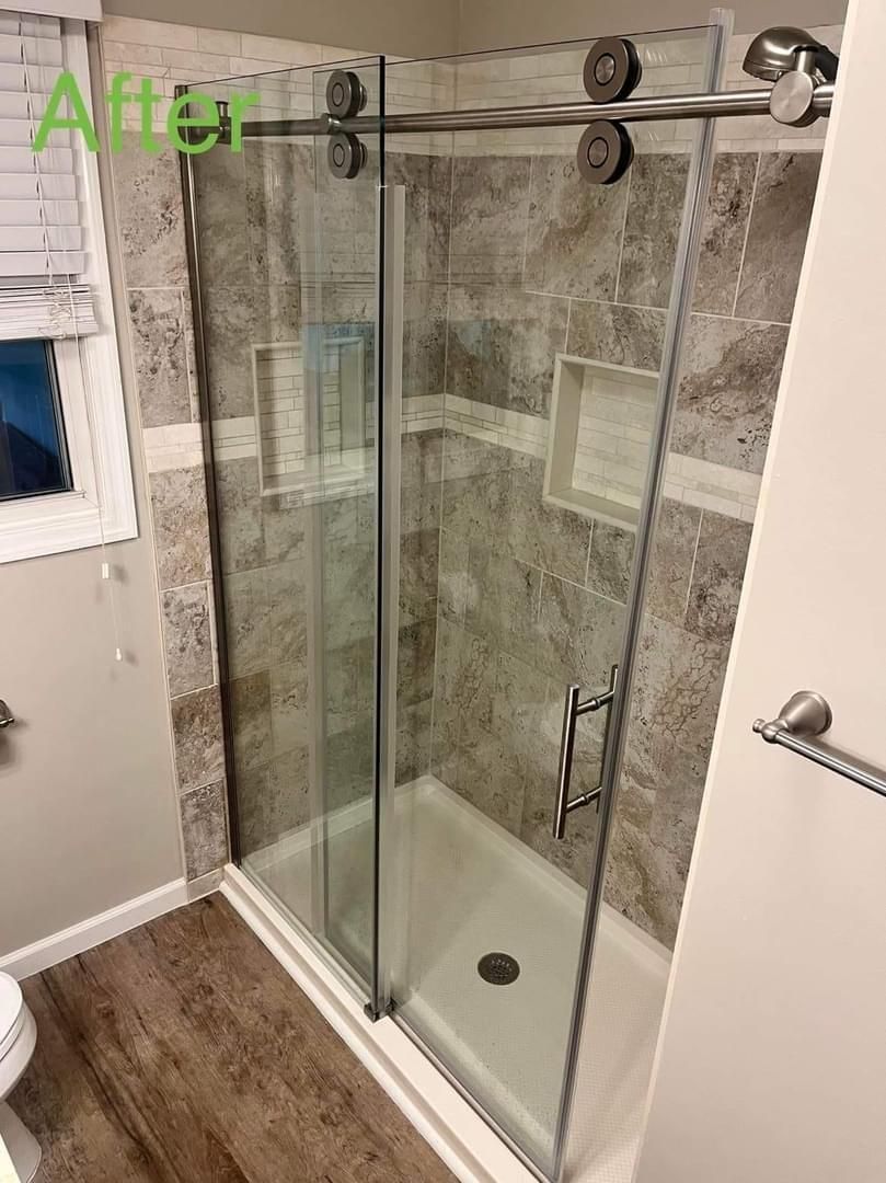 A bathroom with a sliding glass shower door and a toilet.