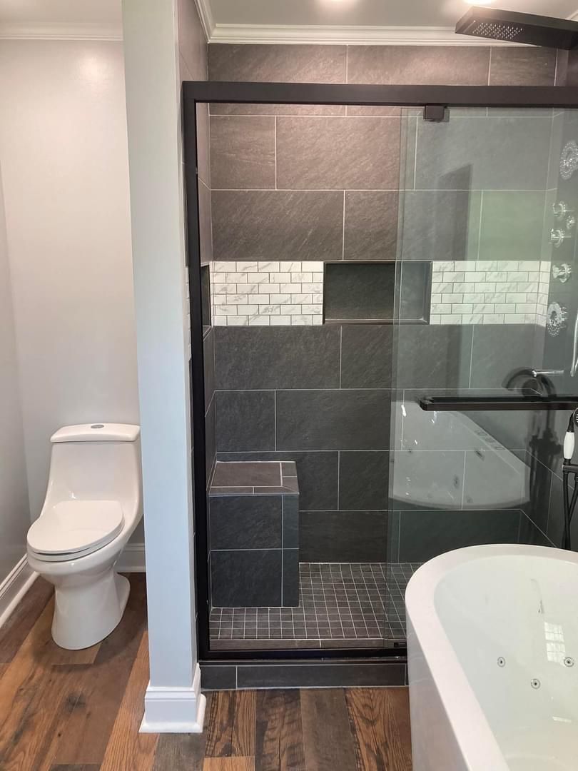 A bathroom with a toilet , tub , shower and walk in shower.