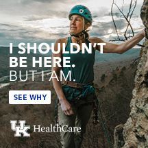 A woman in a helmet is climbing a rock wall.