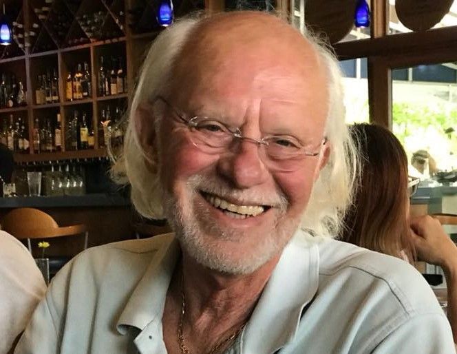 A man with glasses and a beard is smiling for the camera