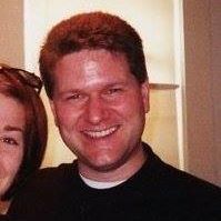 A man and a woman are posing for a picture and smiling for the camera.