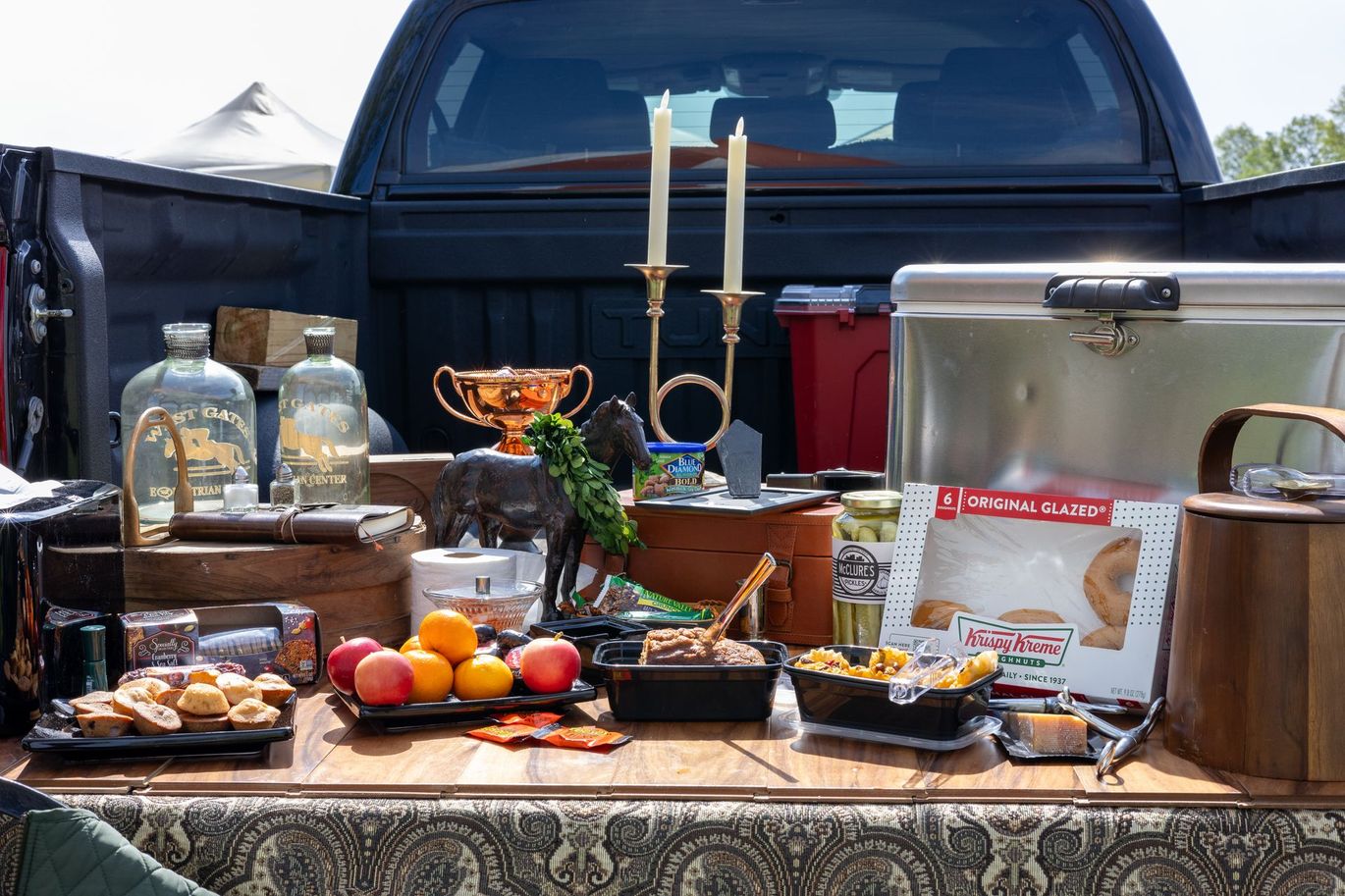 The back of a truck is filled with lots of food and candles.