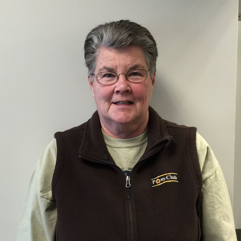 A woman wearing glasses and a brown vest with the word tiger on it