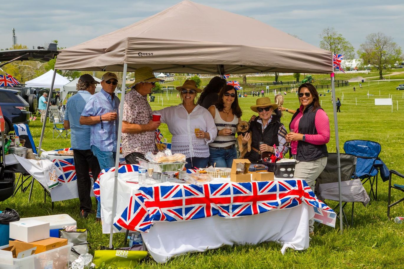 A group of people are standing around a table under a tent.