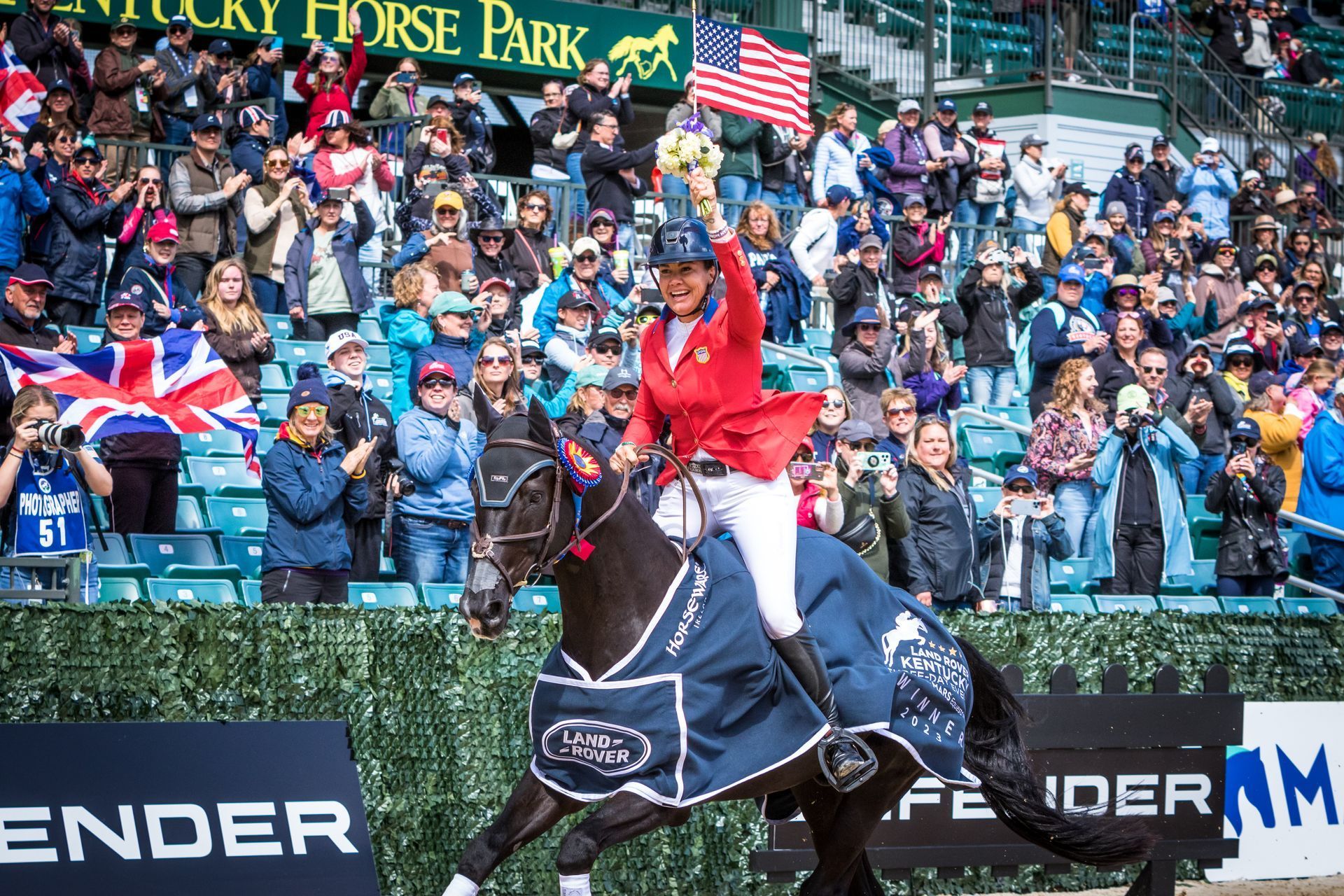 A woman is riding a horse in front of a crowd.