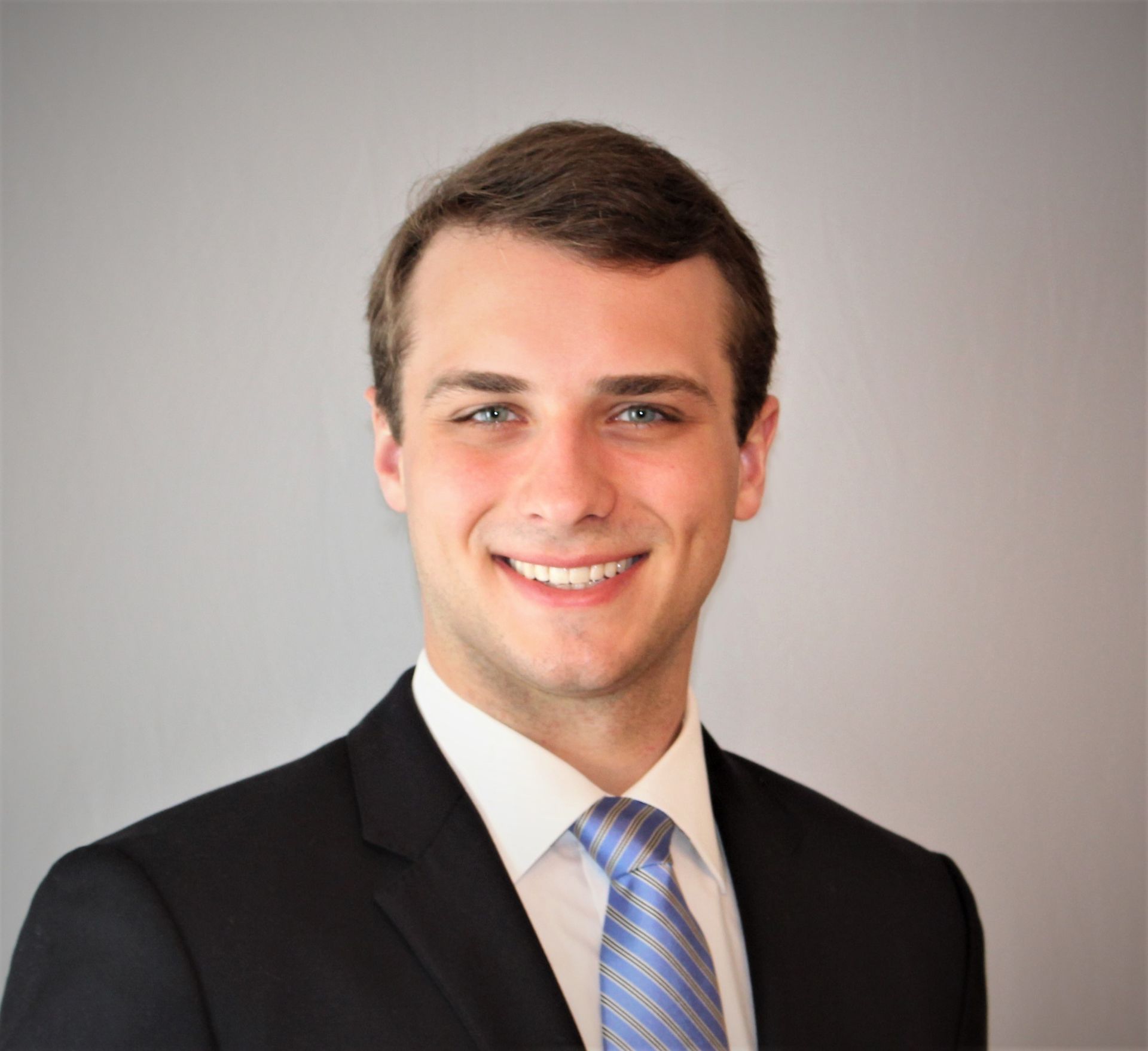 A man in a suit and tie is smiling for the camera.