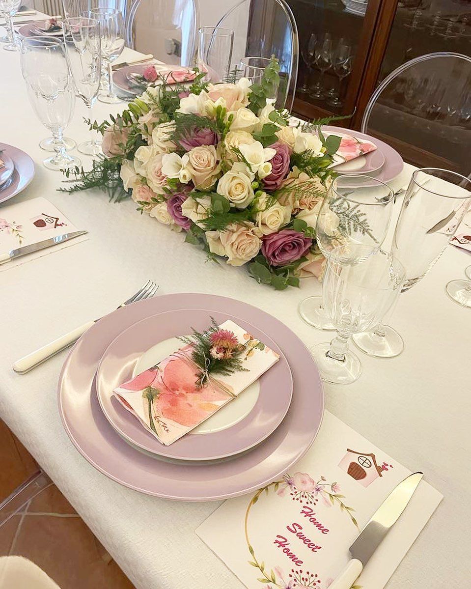 Elegante apparecchiatura da tavola con centrotavola floreale e piatti color lavanda.