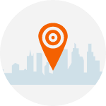 An orange pin with a target on it is in front of a city skyline.