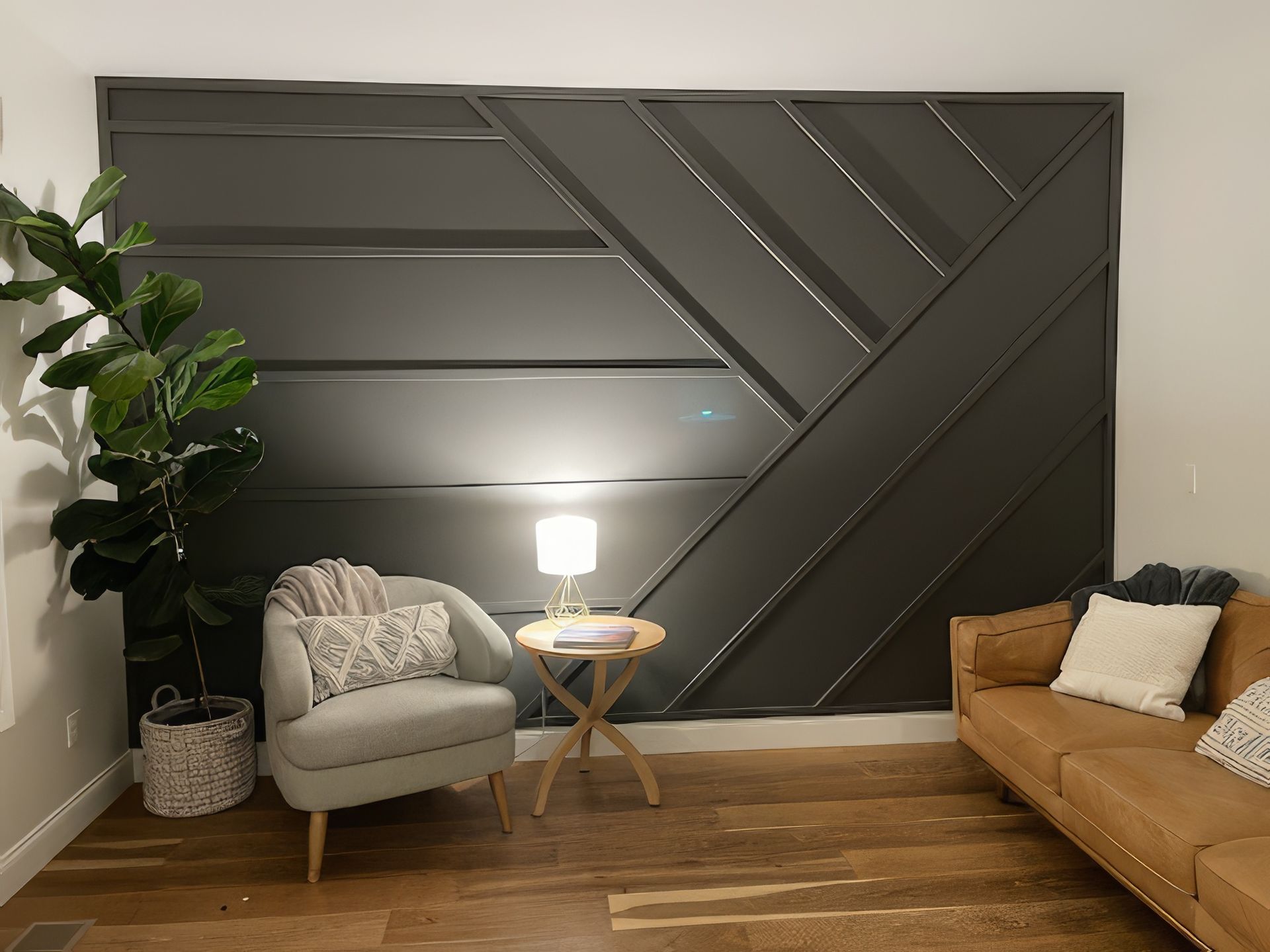 Living room with dark accent wall, chair, sofa, side table, lamp, and plant.