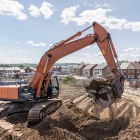 Excavator moving earth on housing building site
