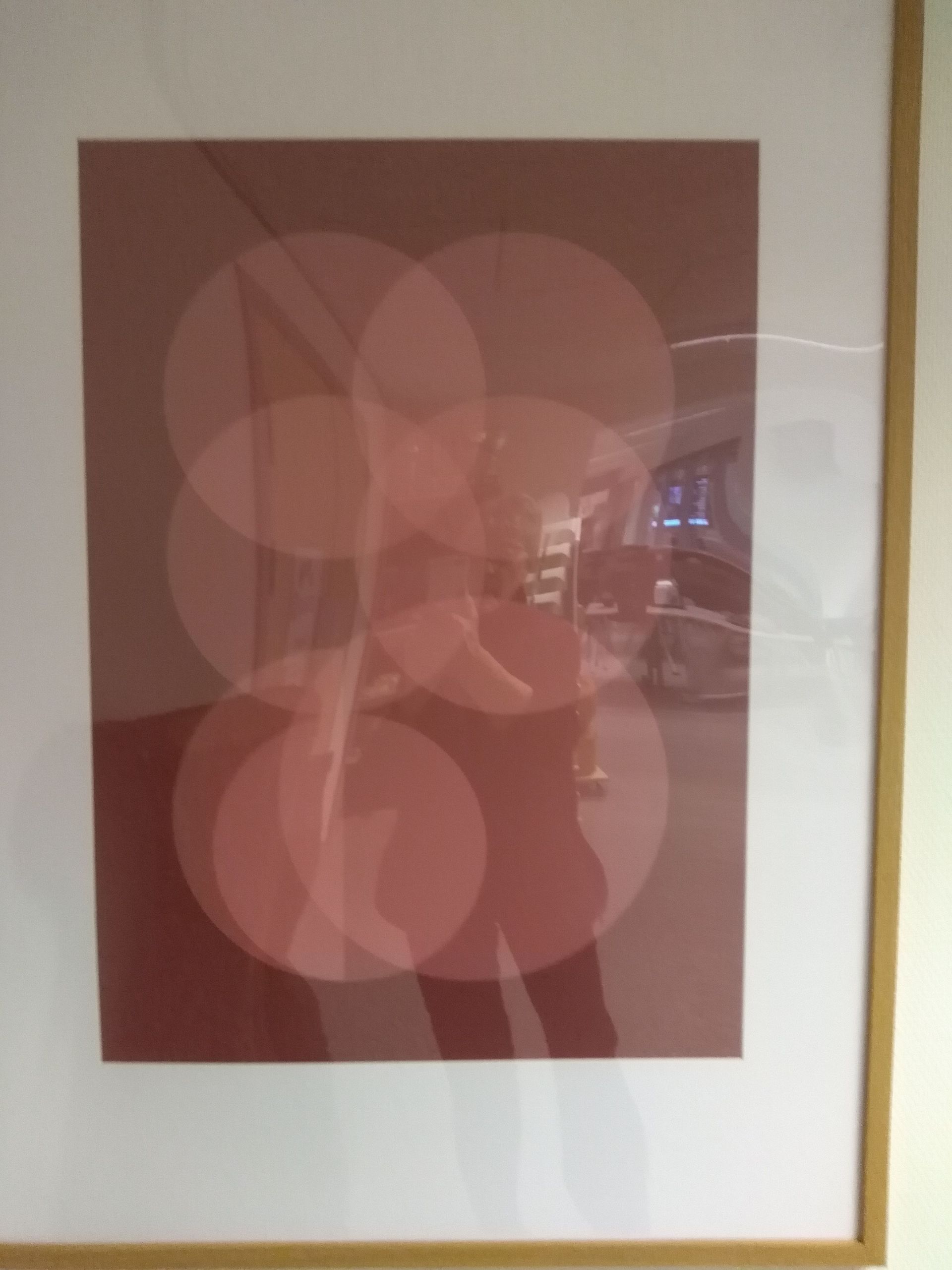 Framed art: overlapping, translucent, pink circles on a maroon background.