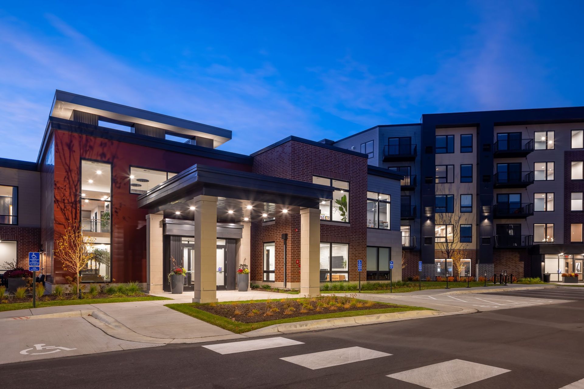 A large brick building with a canopy over the entrance at night.