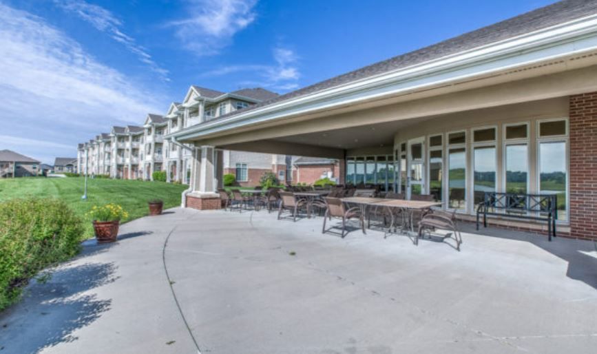 A large patio with tables and chairs in front of a large building.