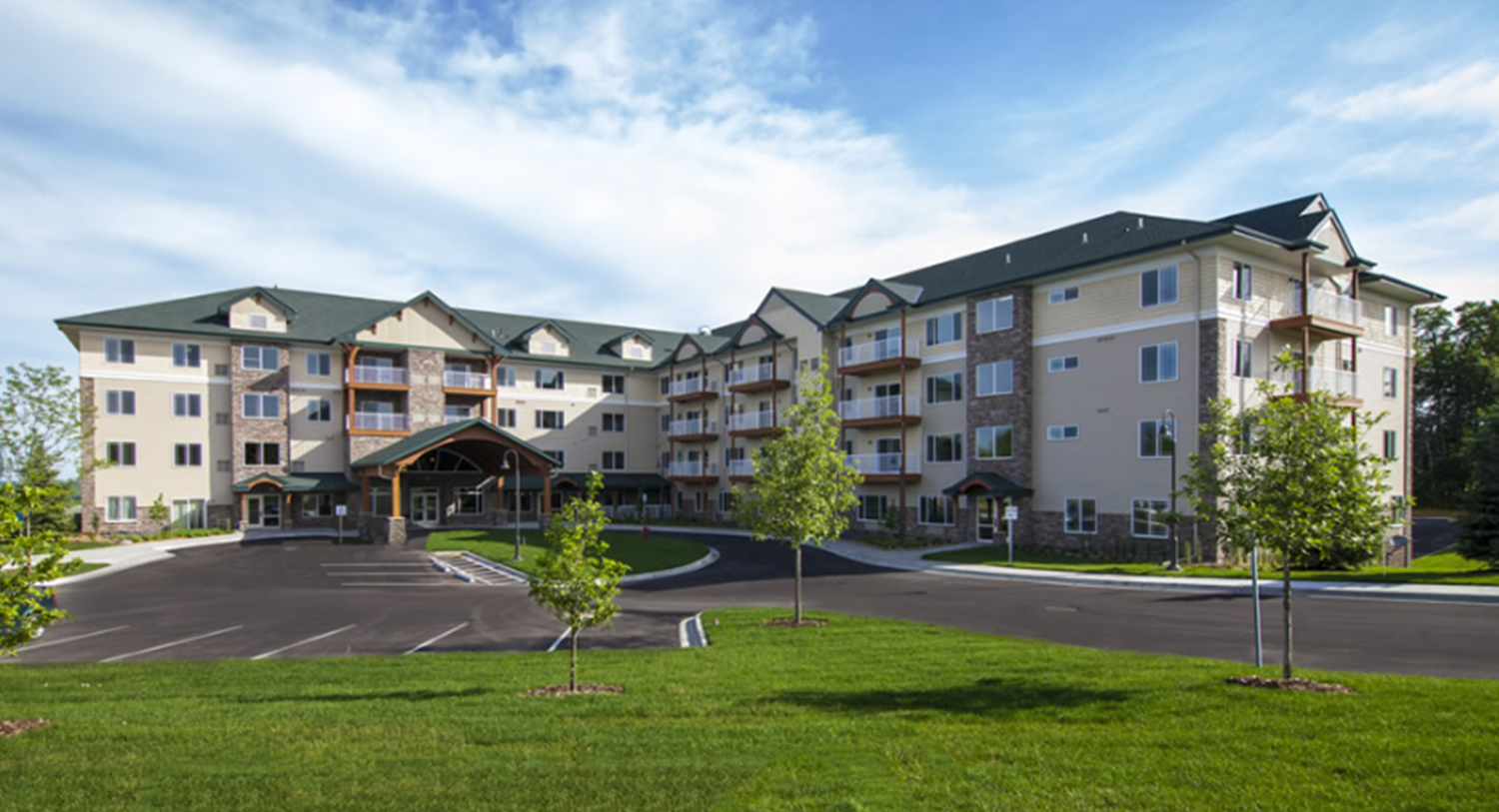 A large apartment building with a parking lot in front of it.