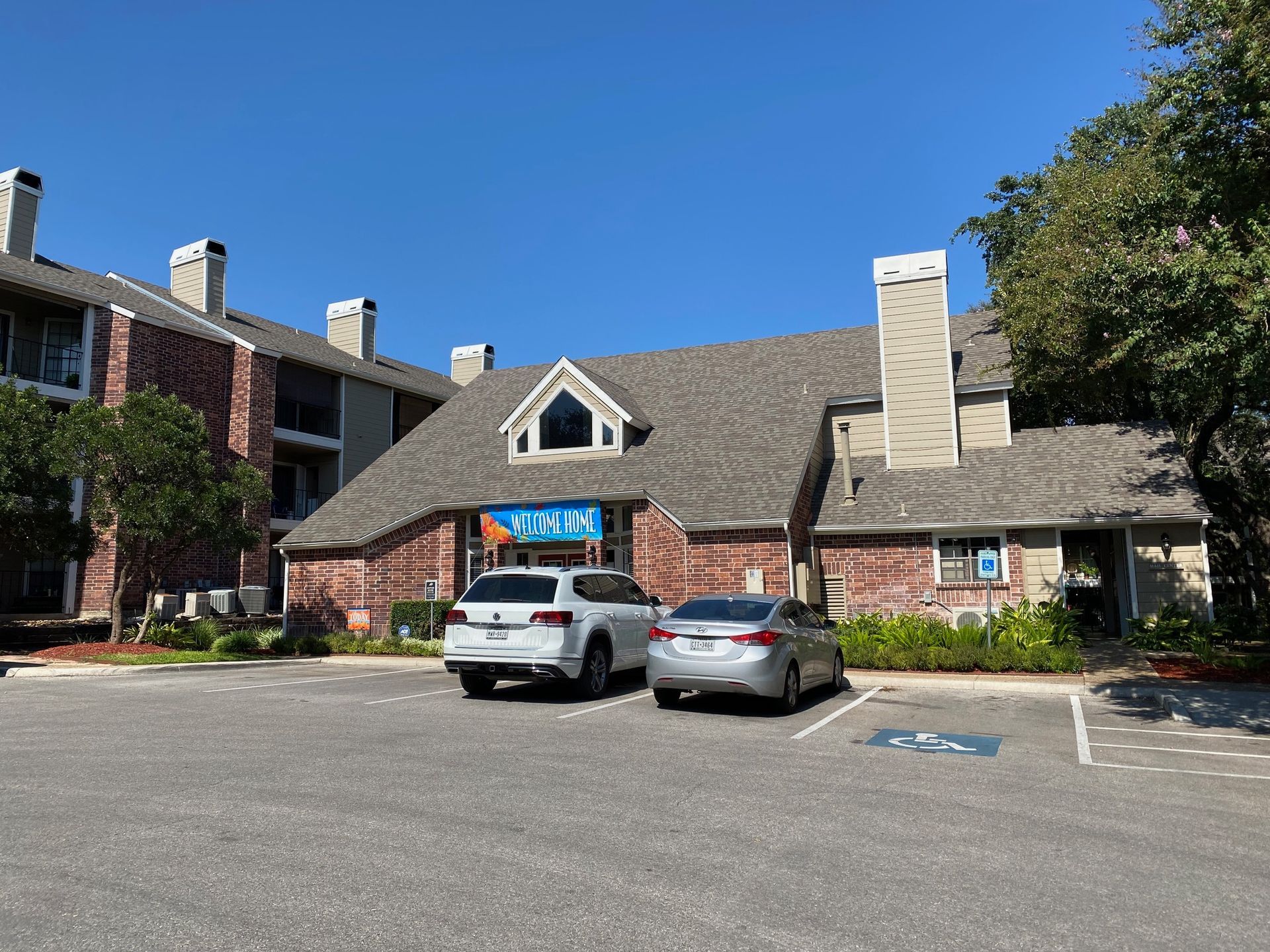 Two cars are parked in front of a brick building