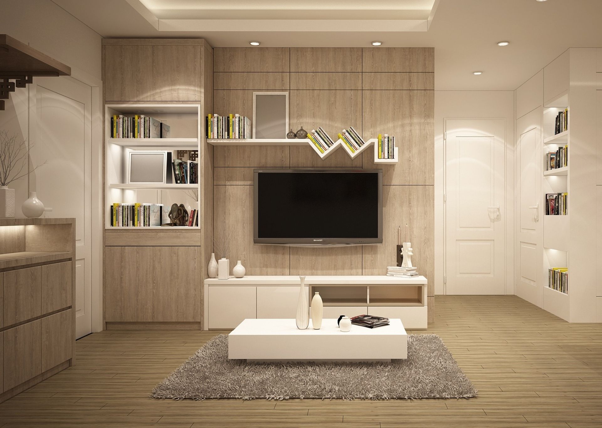 Modern living room with light wood paneling, TV, white furniture, and bookshelves.