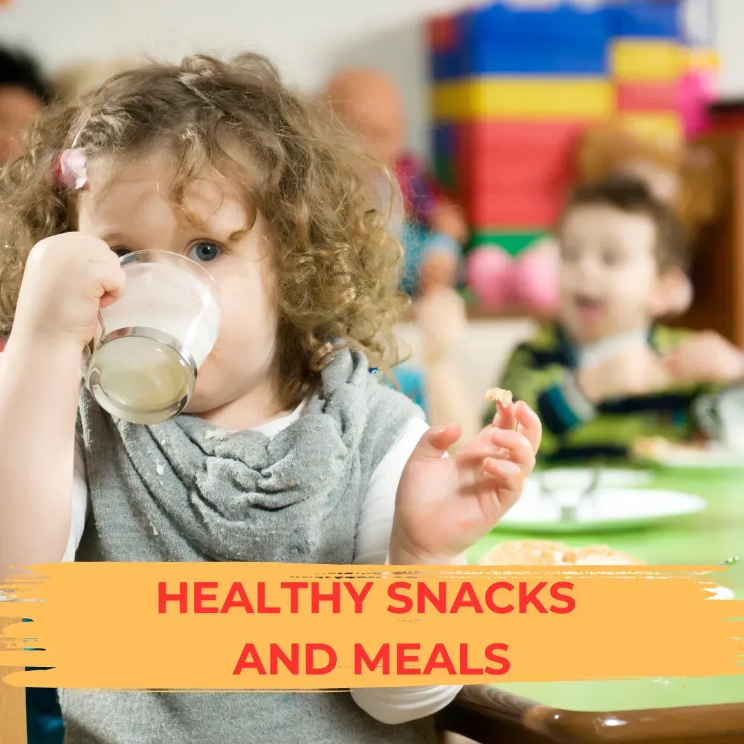 A little girl is drinking milk from a cup while sitting at a table.