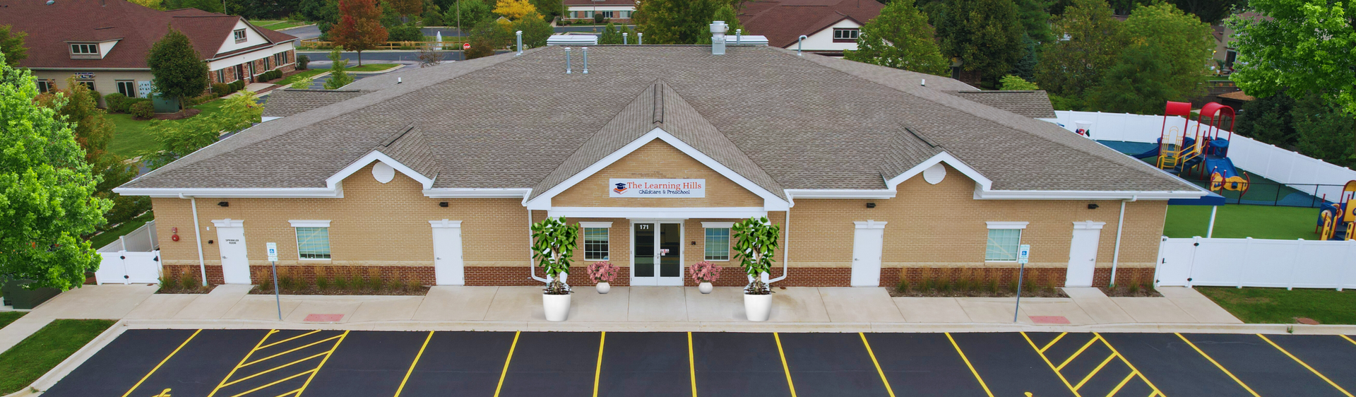 An aerial view of a large building with a parking lot in front of it.