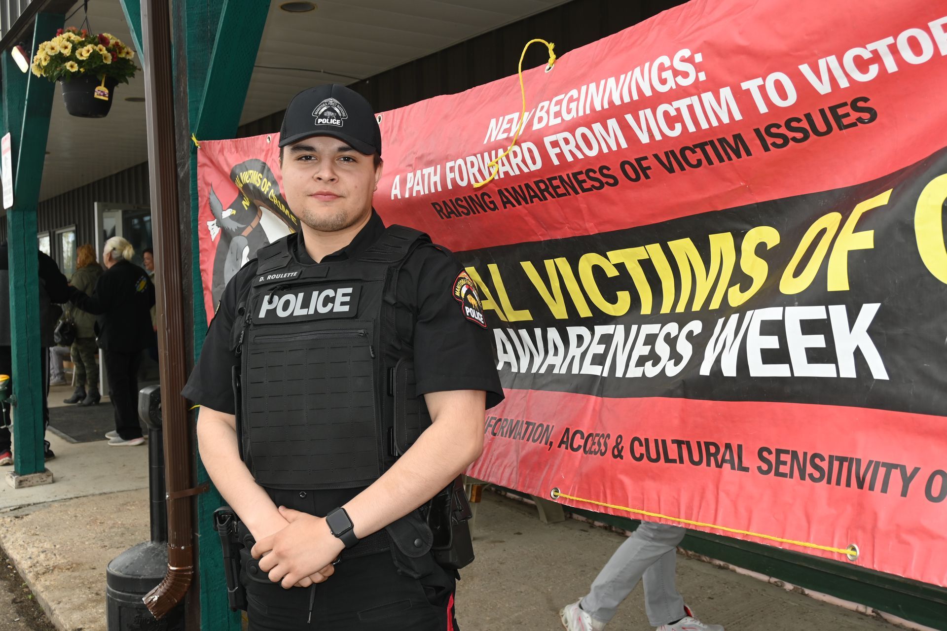 MFNPS-Manitoba First Nations Police Service Officer in front of Victim Crimes banner