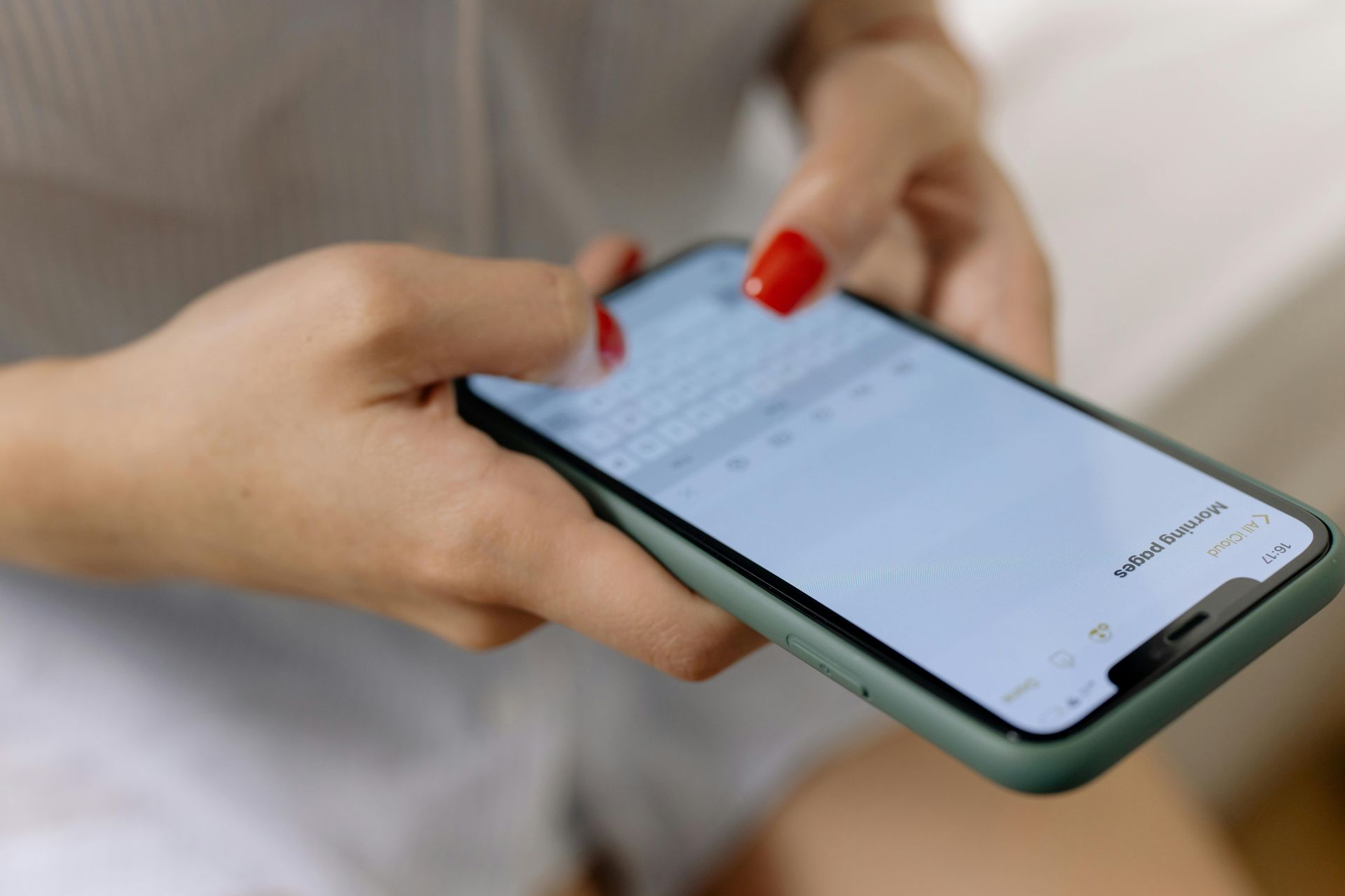 Hands with red nails using a smartphone with a chat screen