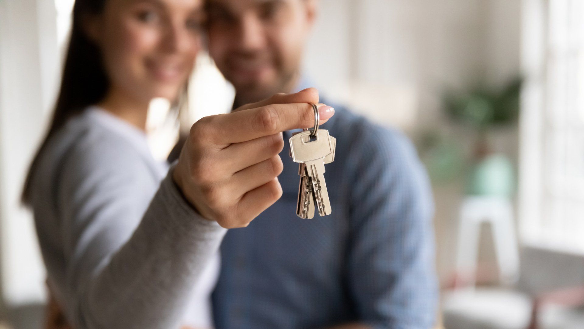 couple embracing with woman holding keys