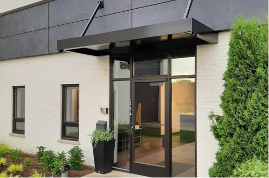 A white building with a black awning over the entrance.