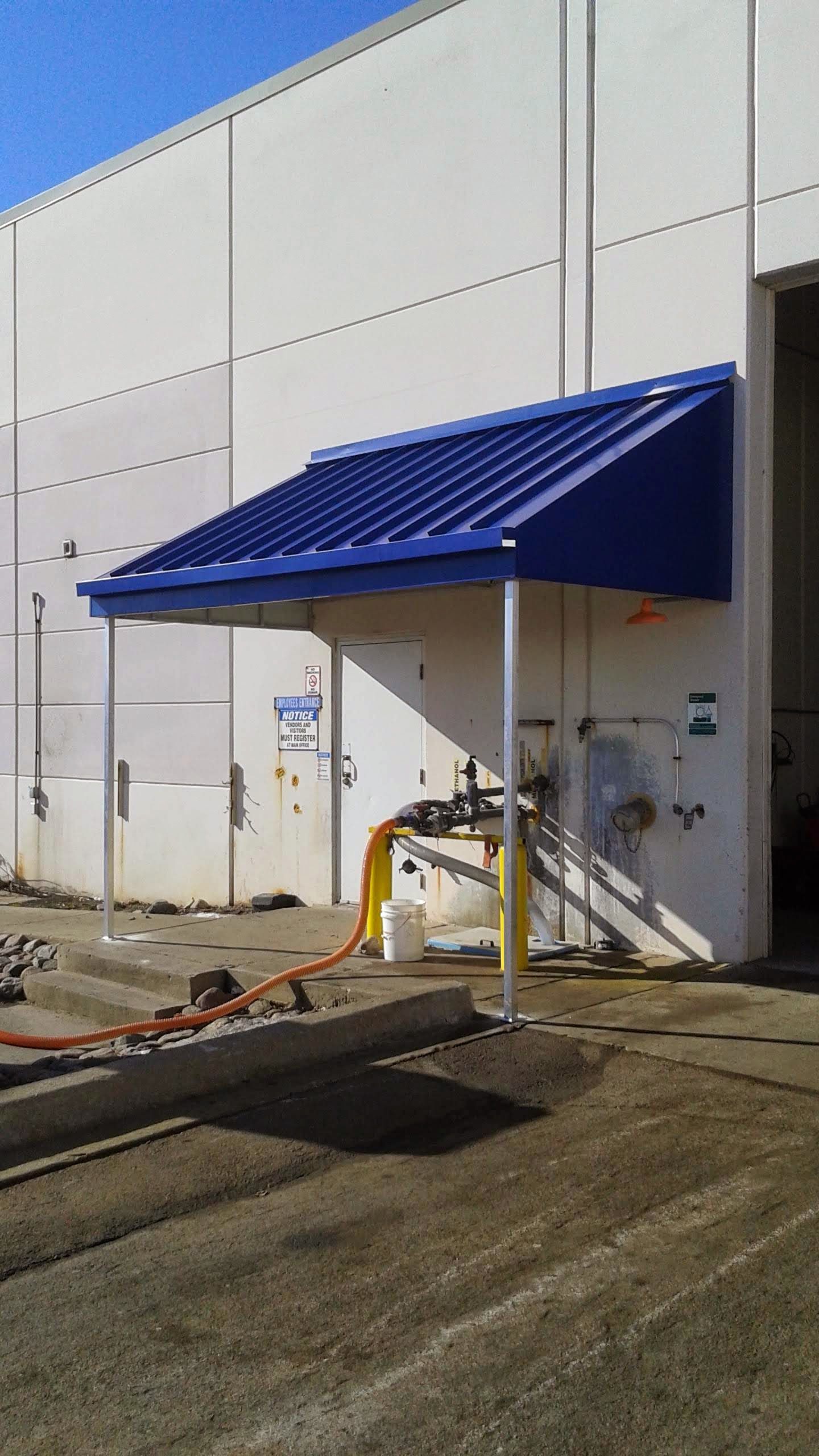 A blue awning is attached to the side of a building.