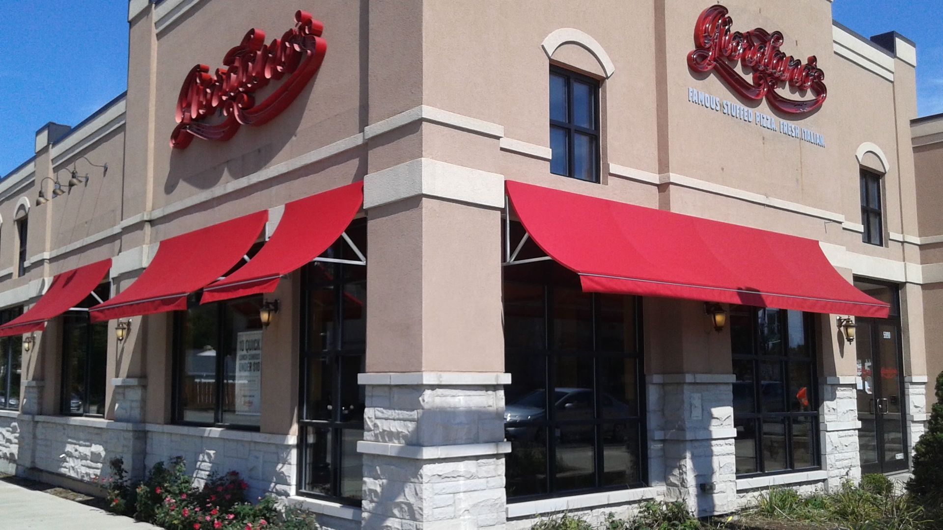 A restaurant with red awnings and a sign that says ' ricky 's ' on it
