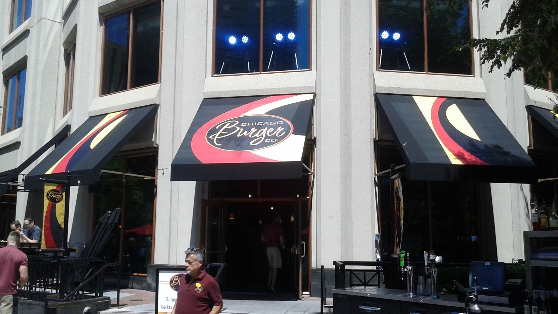 A man standing in front of a building with a sign that says ' chicago ' on it