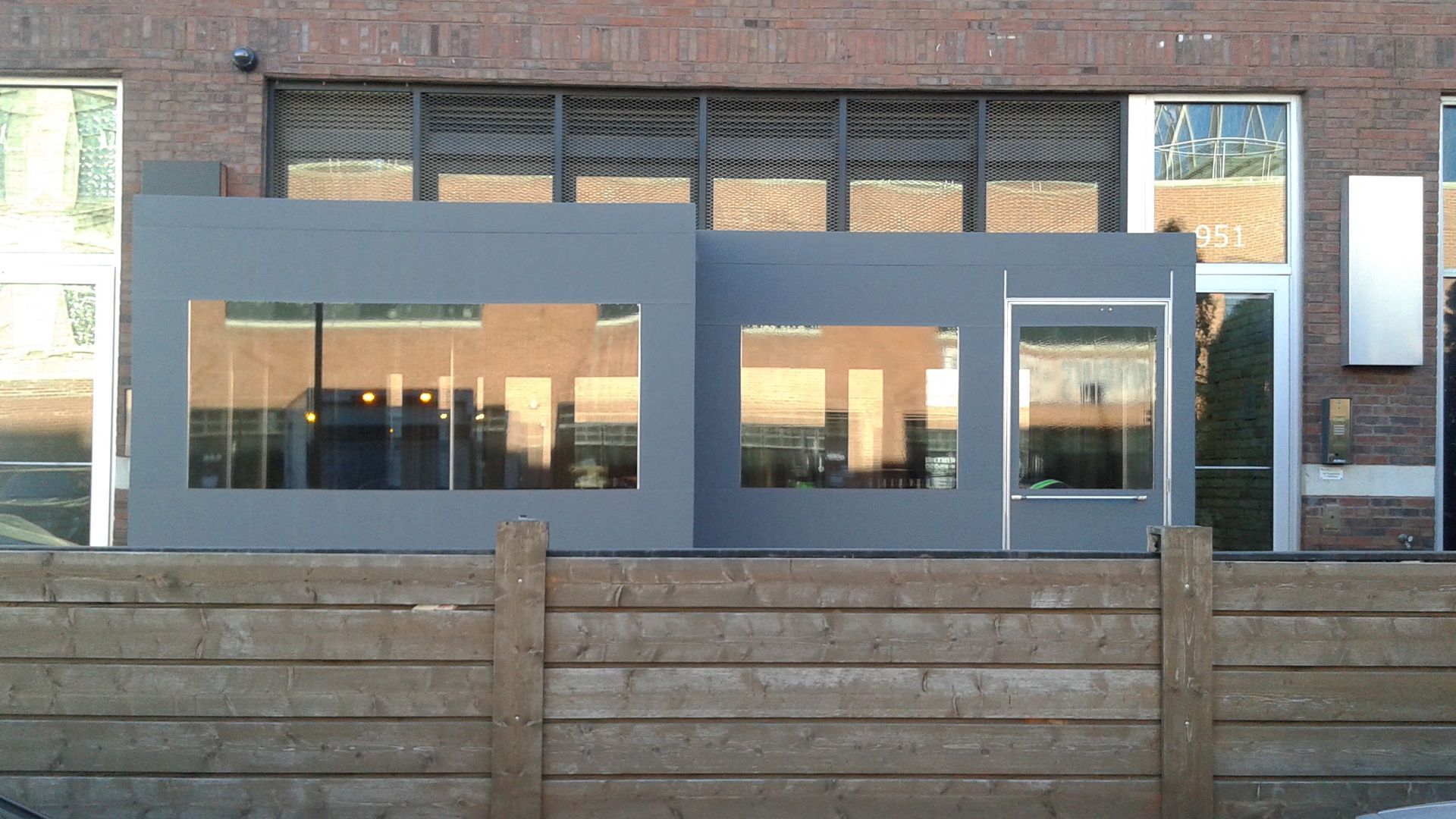 A brick building with a wooden fence in front of it