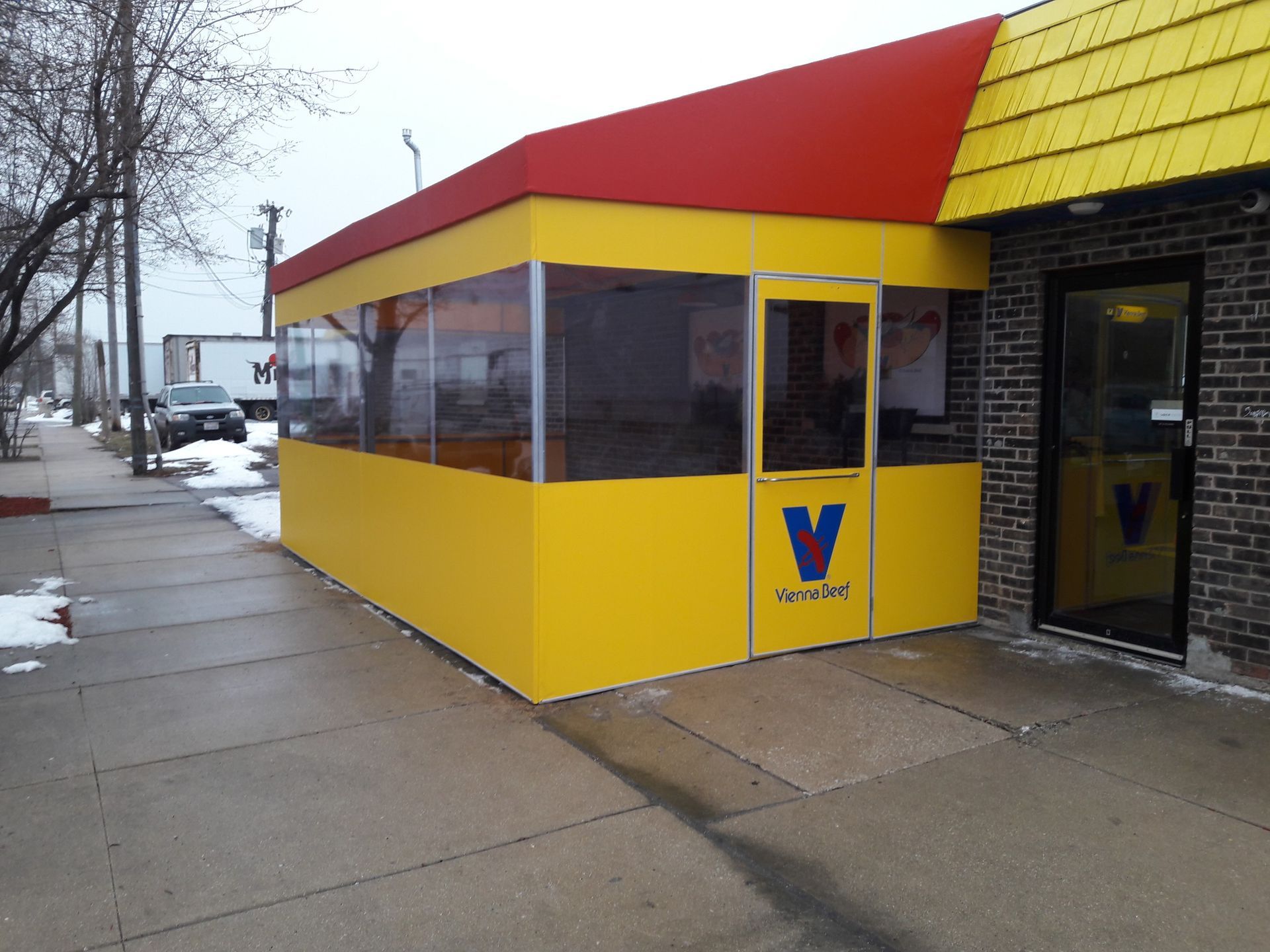 A yellow building with the letter v on the door