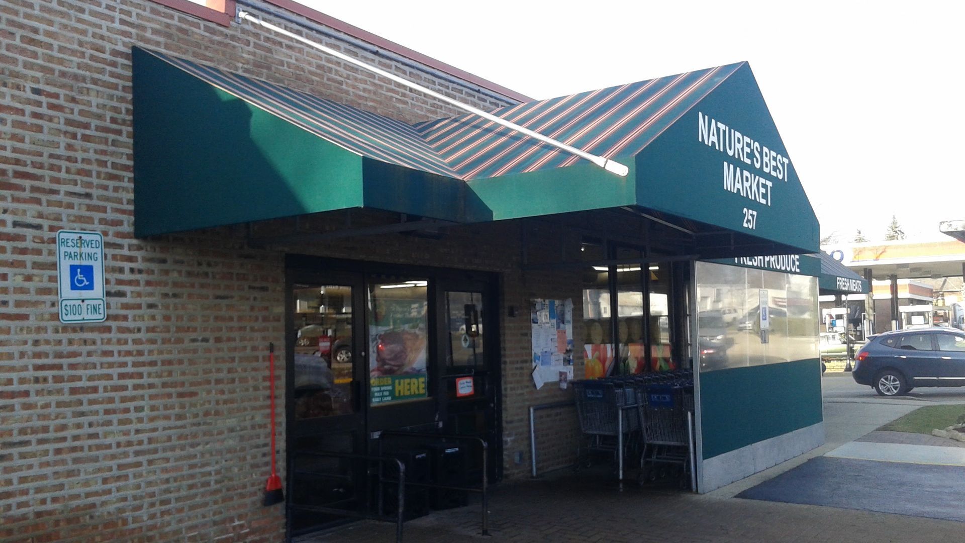 A brick building with a green awning over the entrance