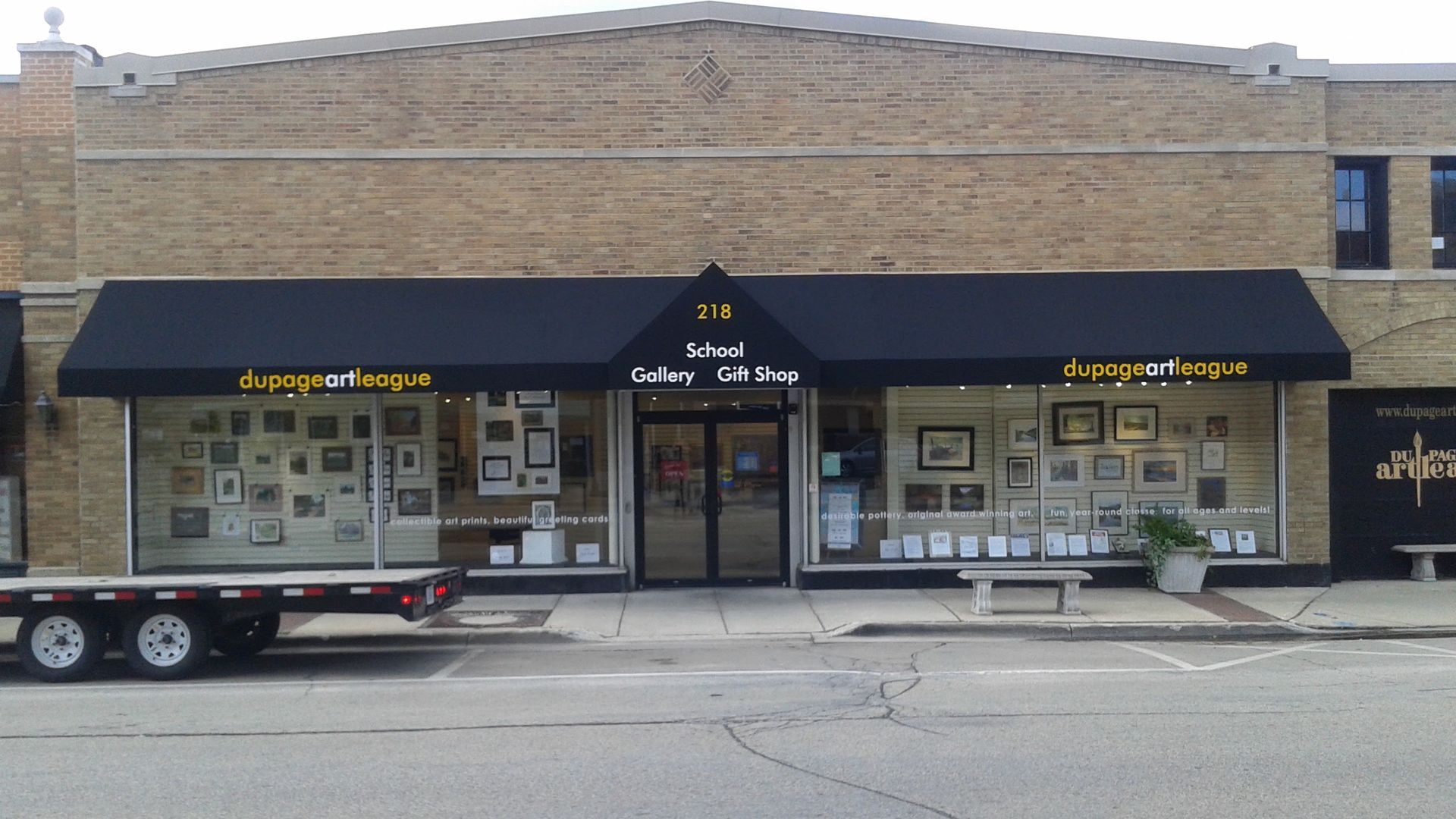A brick building with a black awning that says ideal