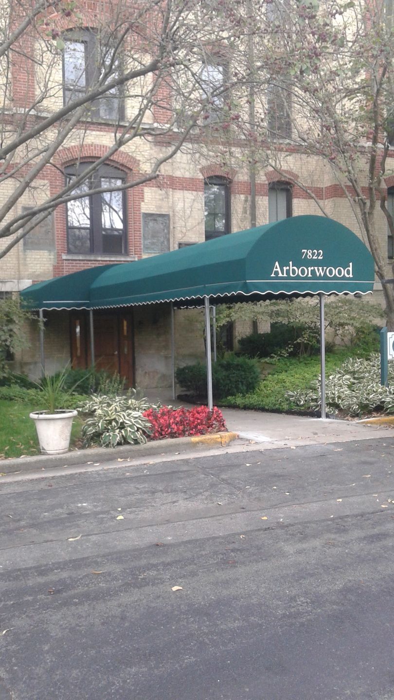 A green awning is covering the entrance to a building.