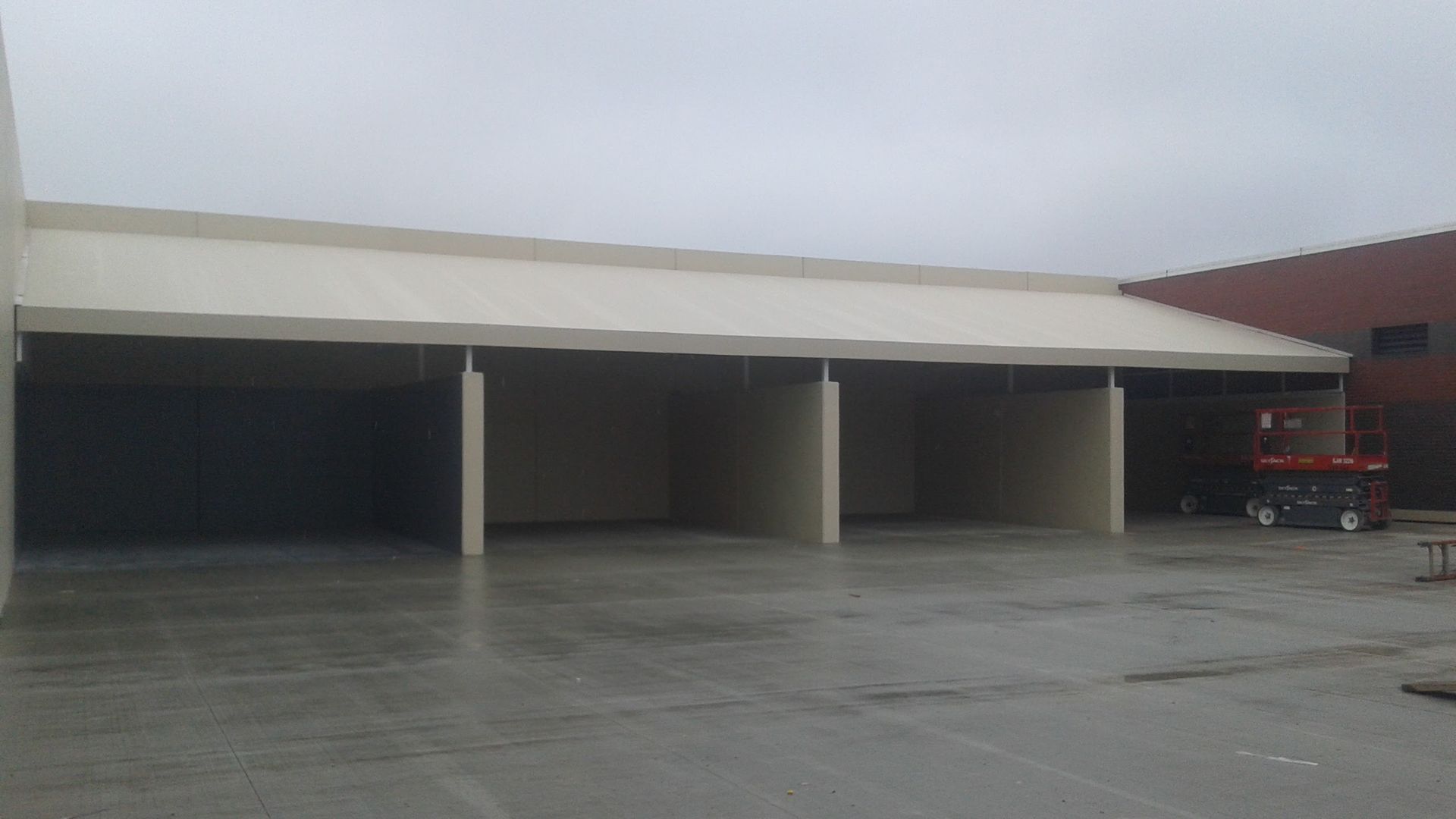 A large building with a white roof and a concrete floor.