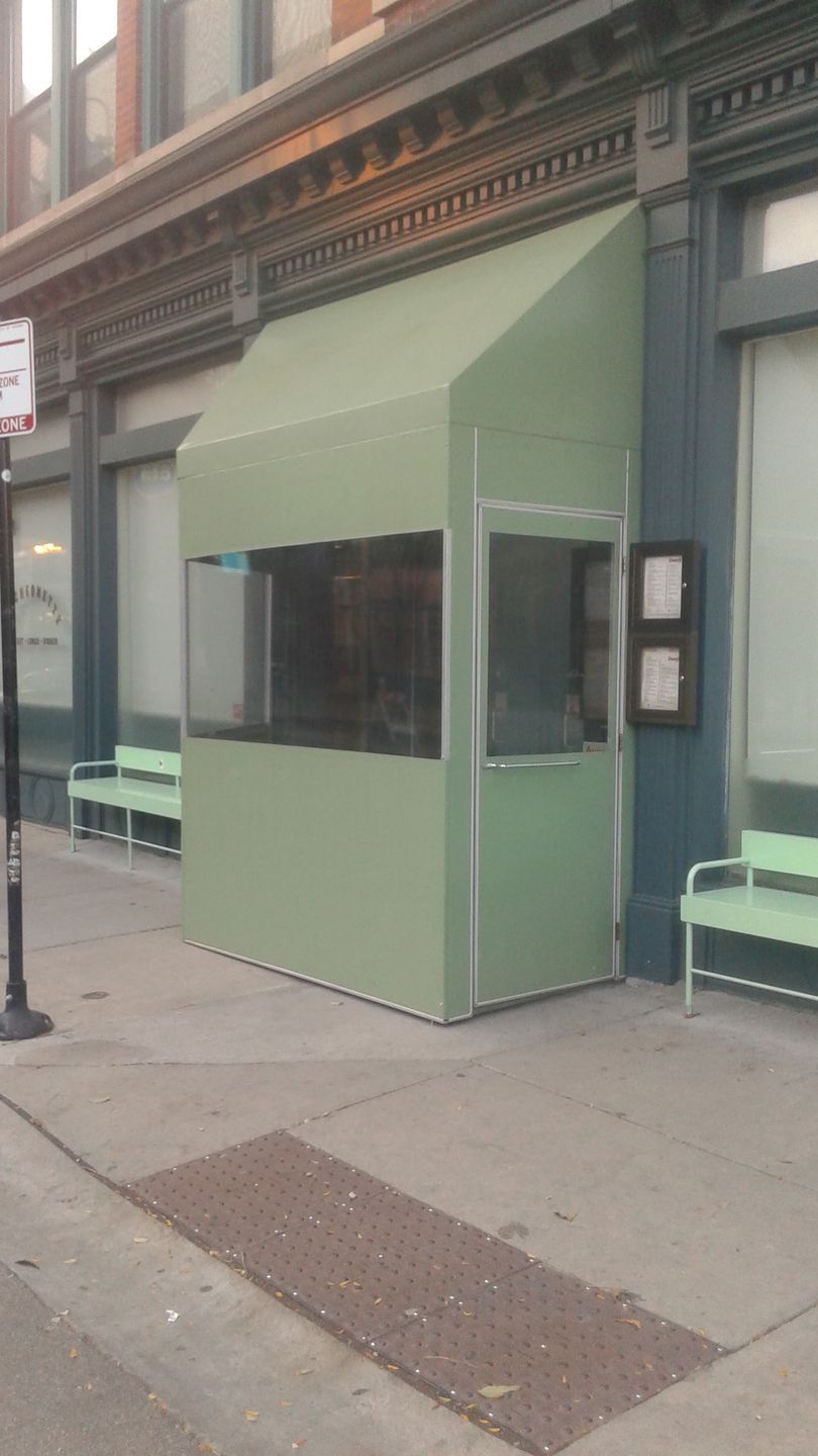 A green awning is on the side of a building