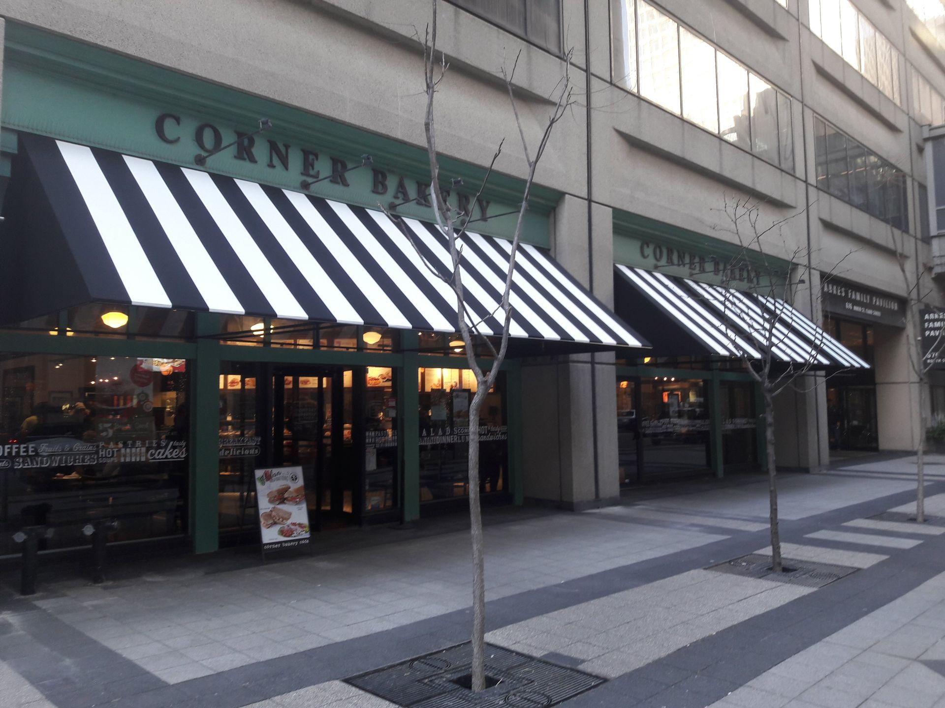 A building with a black and white awning that says corner bakery