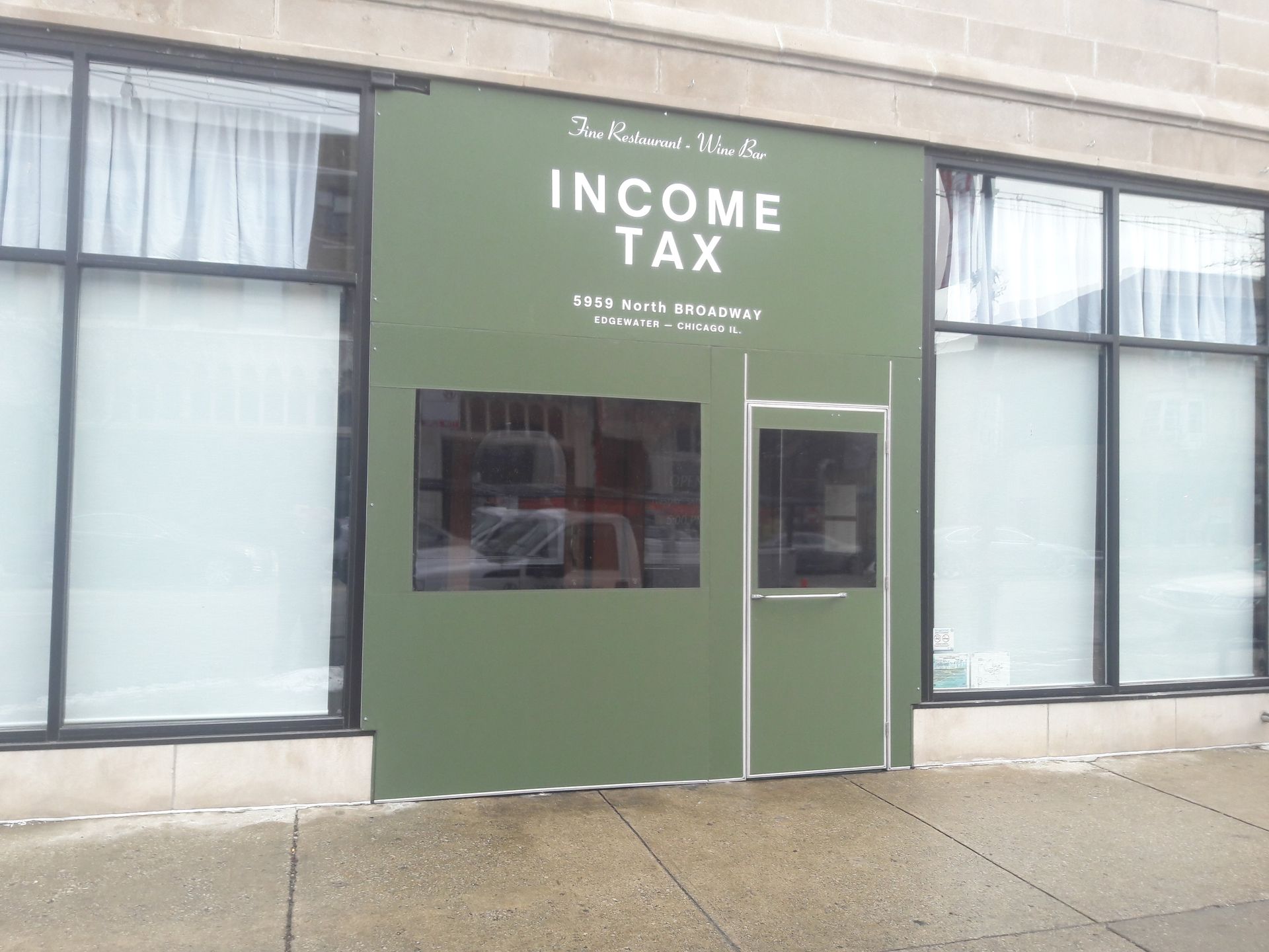 A green building with a sign that says income tax