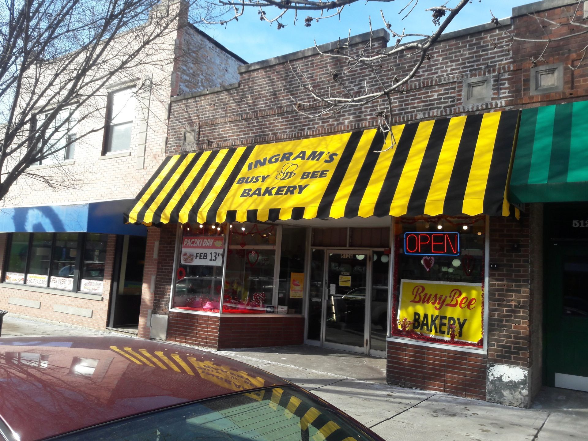 A bakery with a yellow and black awning that says open
