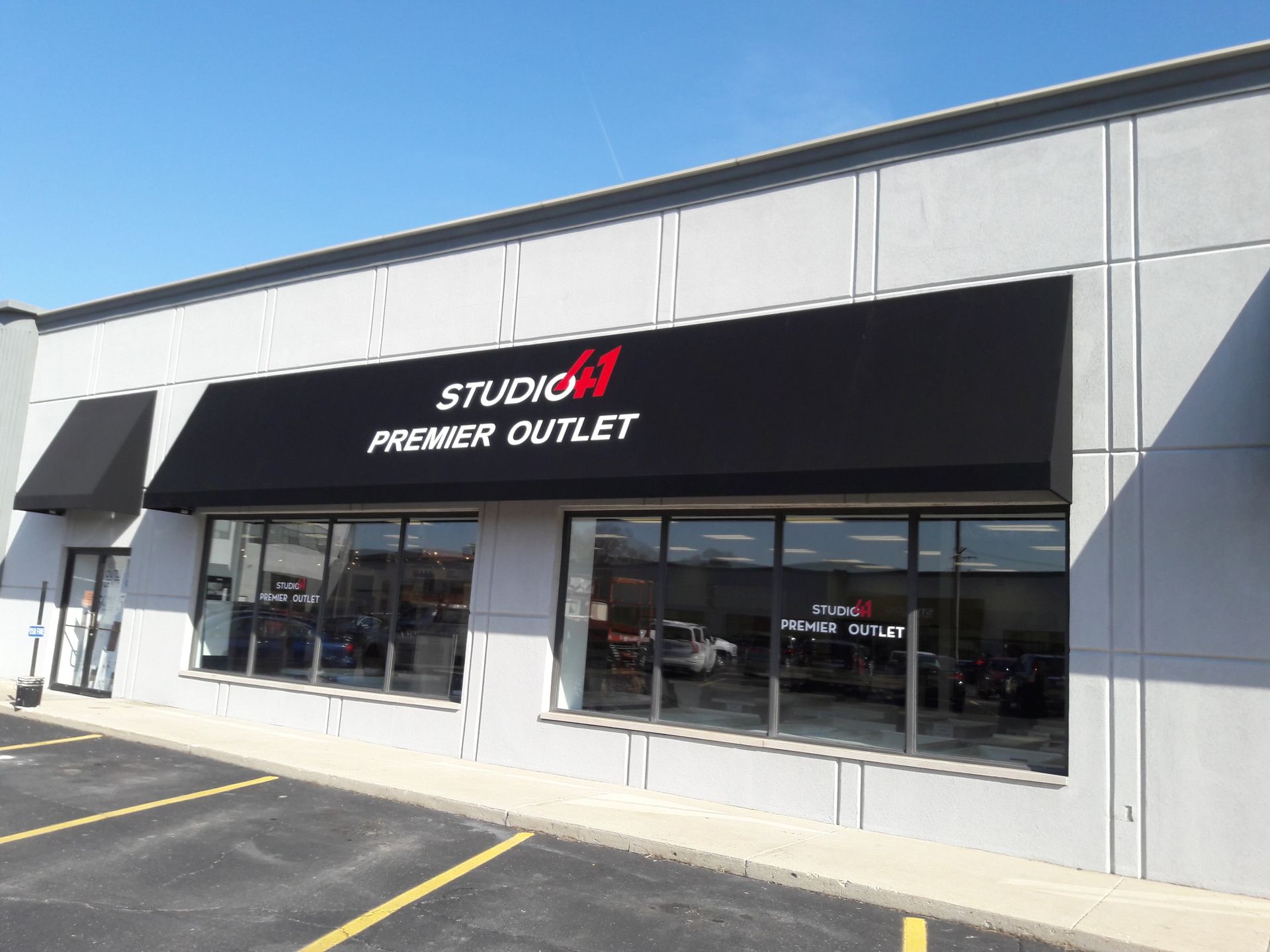 A building with a black awning that says studio premier outlet