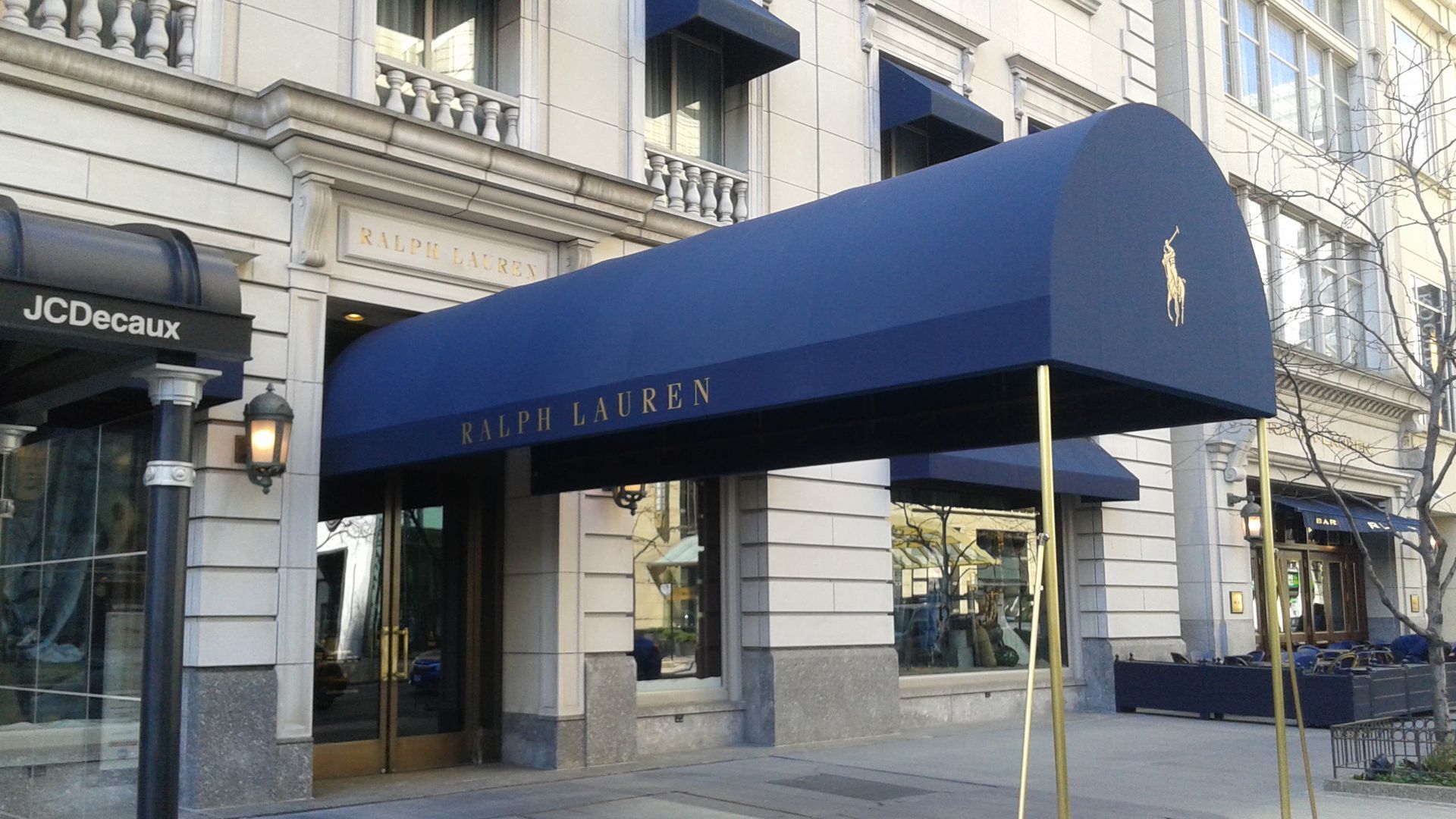 A store front with a blue awning that says ralph lauren