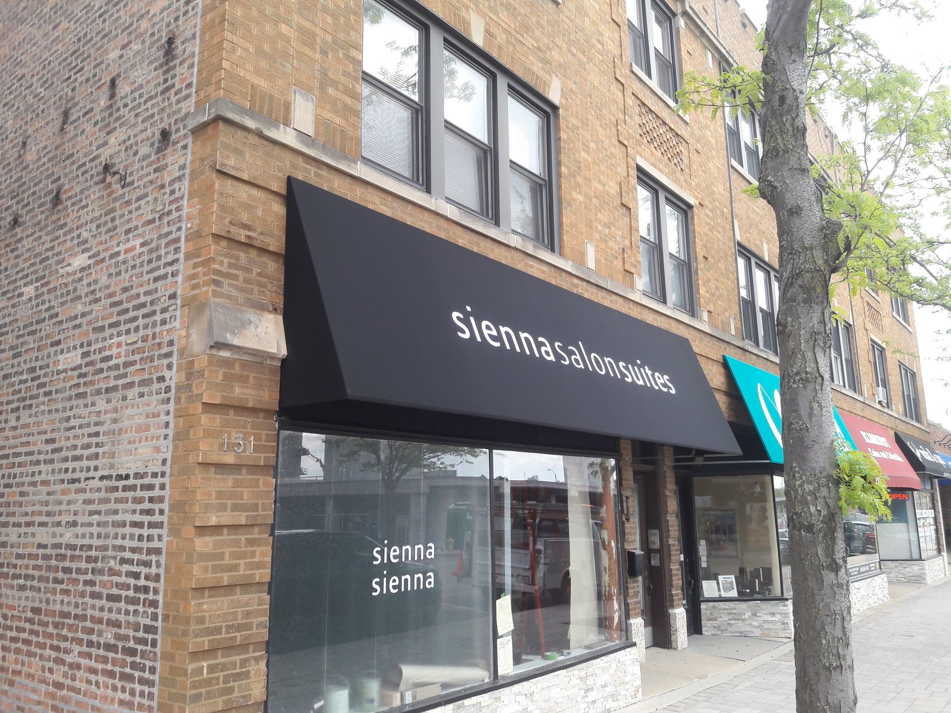 A store front with a black awning that says sienna sienna