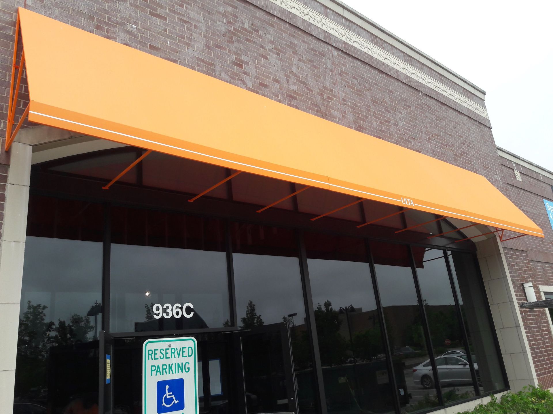 A building with an orange awning and a handicapped parking sign