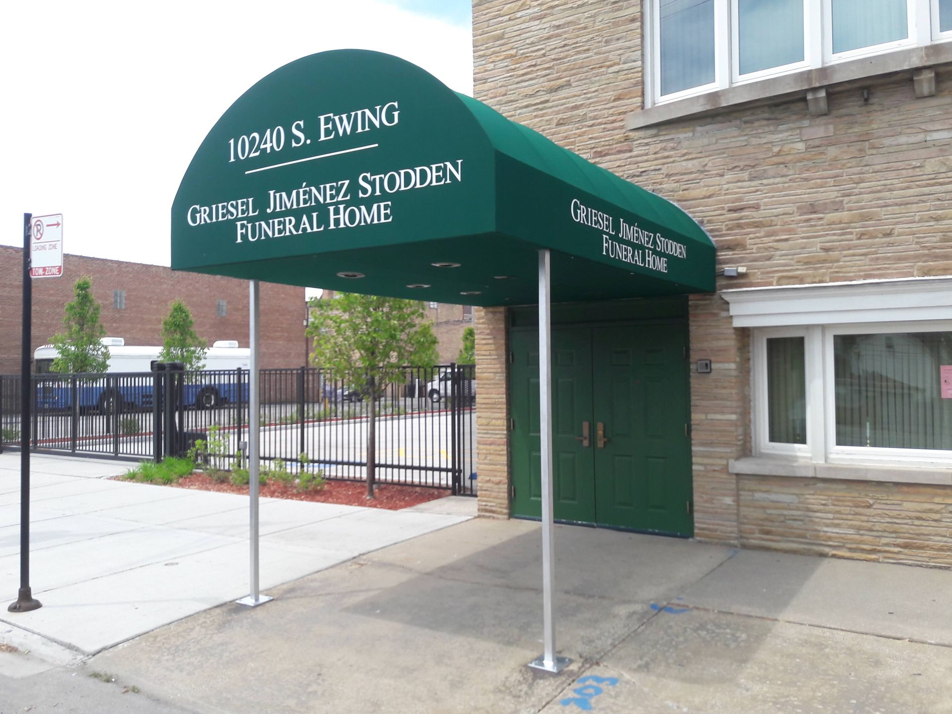 A green awning over the entrance to jesus ewing funeral home